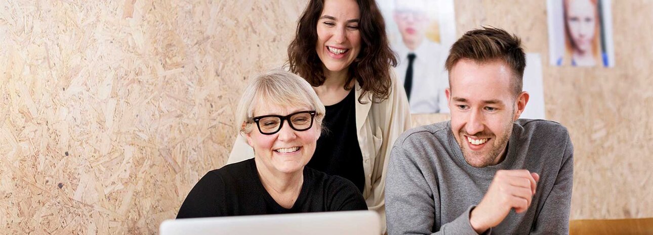 Tre glada förskolepedagoger framför en dator | © Scandinav bildbyrå